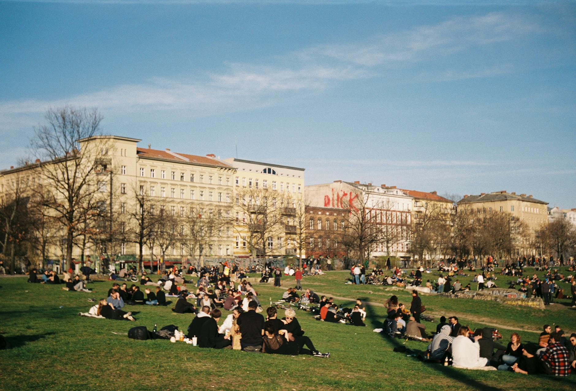 A vibrant gathering of people enjoying a sunny day at a park in Berlin, Germany.