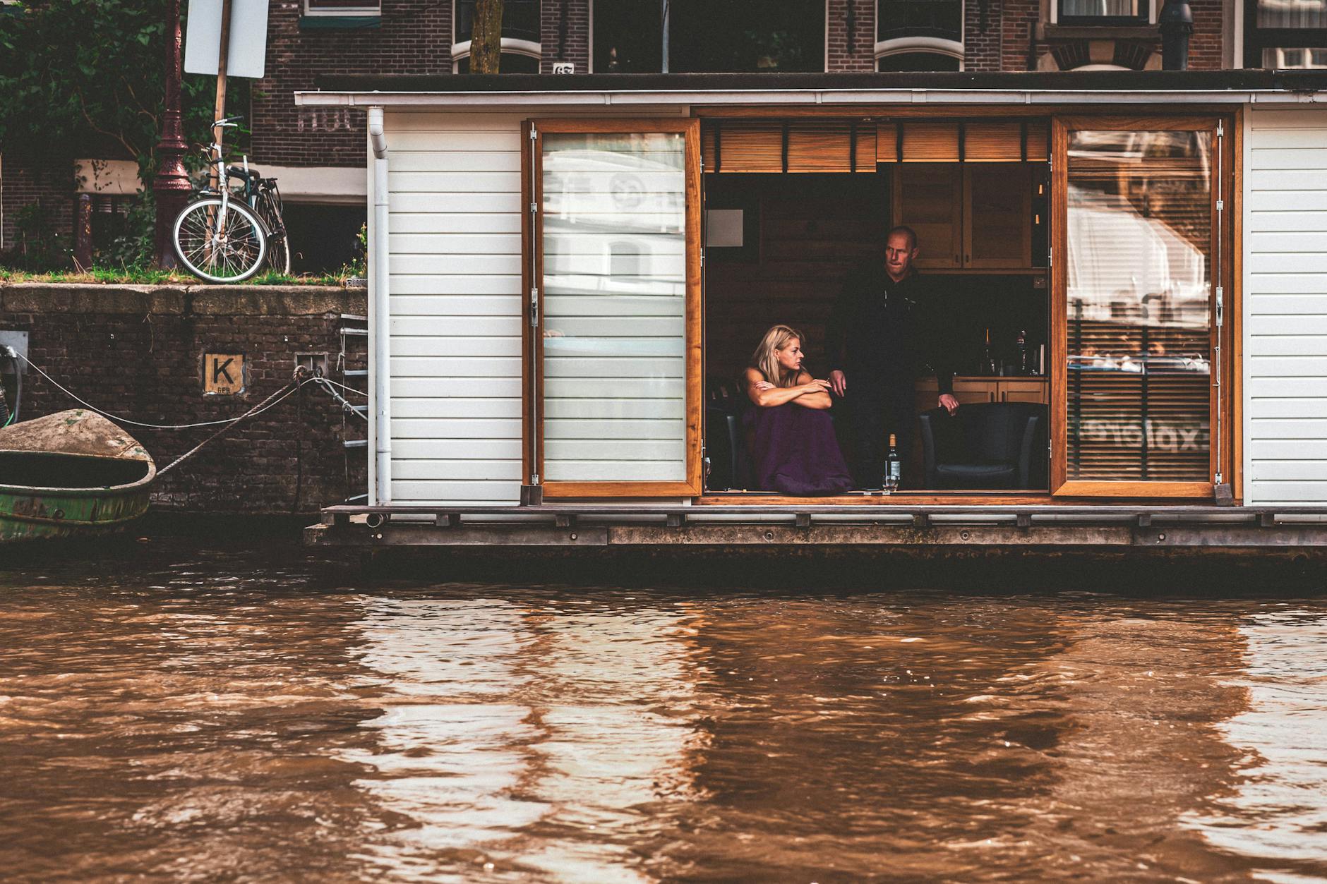 Enjoy peaceful moments on an Amsterdam houseboat along a serene Dutch canal.