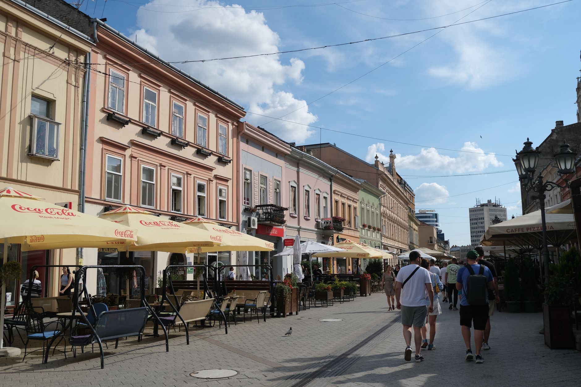 Street view of Novi Sad, Serbia with people enjoying outdoor cafes.